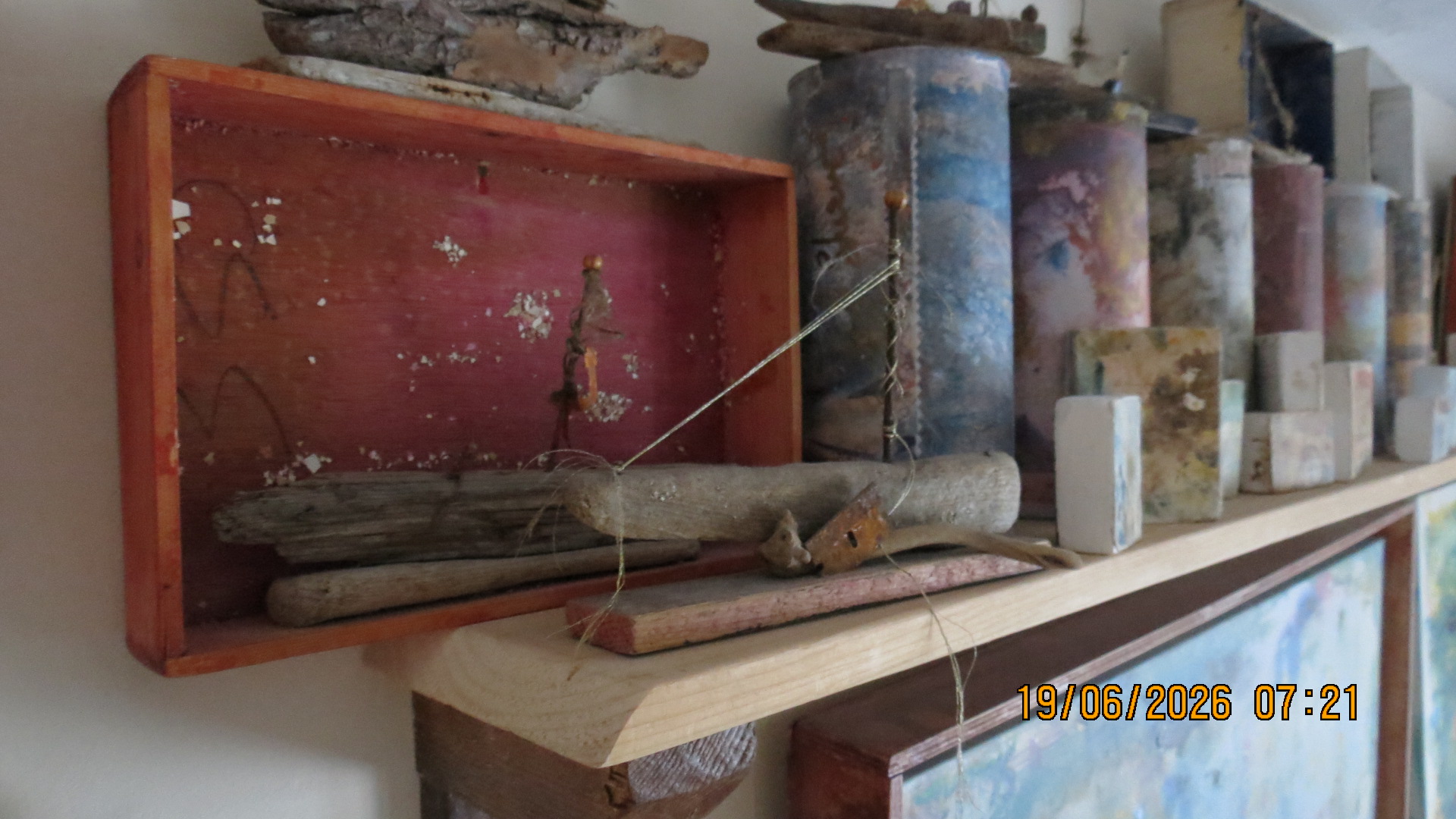 Driftwood boats and assemblage on studio shelf